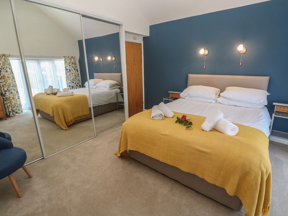 A bedroom with a bed and mirrors at Meadowside in Mousehole