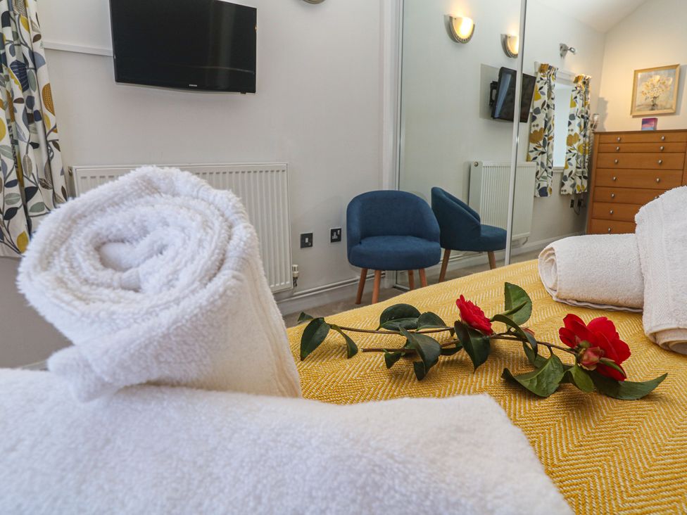 A bedroom with towels and a TV at Meadowside in Mousehole
