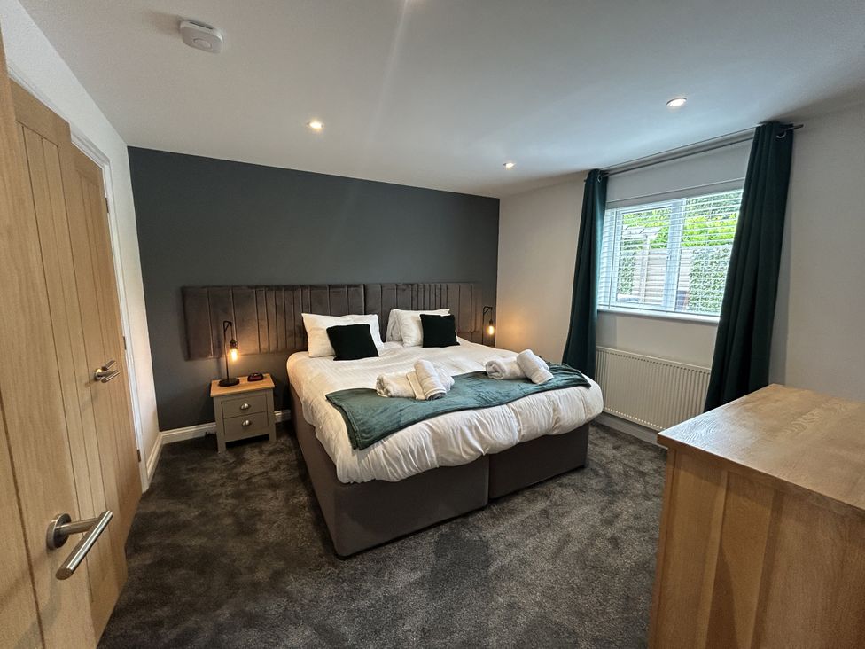 A bedroom with a bed and two nightstands at Willow, Retallack near St Columb Major