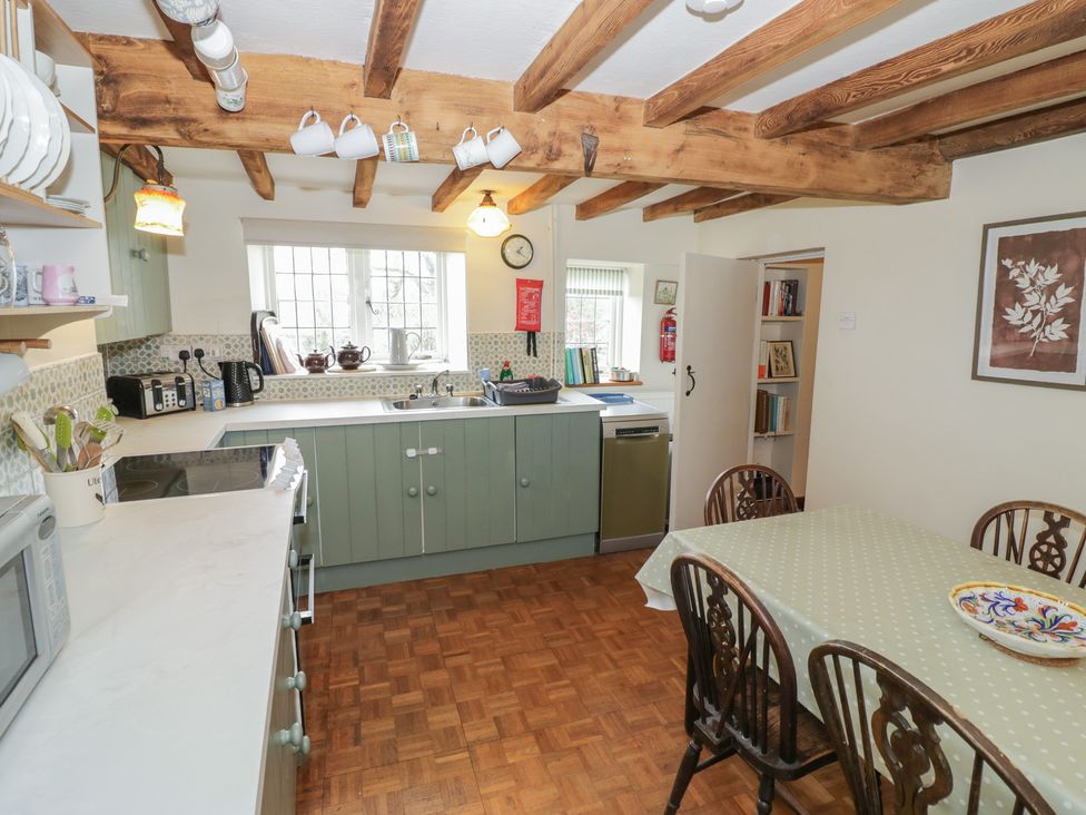 A kitchen with a dining table and appliances at Priors Mead in Claydon near Cropredy