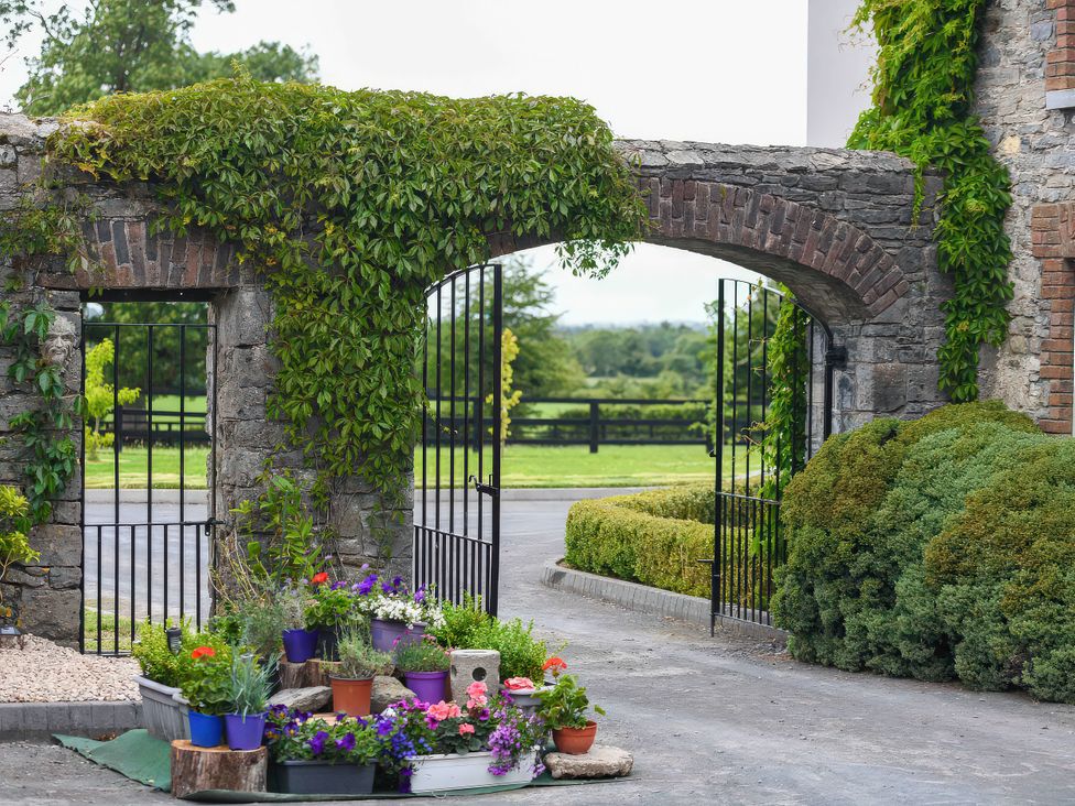 A garden entrance with stone walls and gates at Coach House Kilbeg near Borris-In-Ossory, County Laois