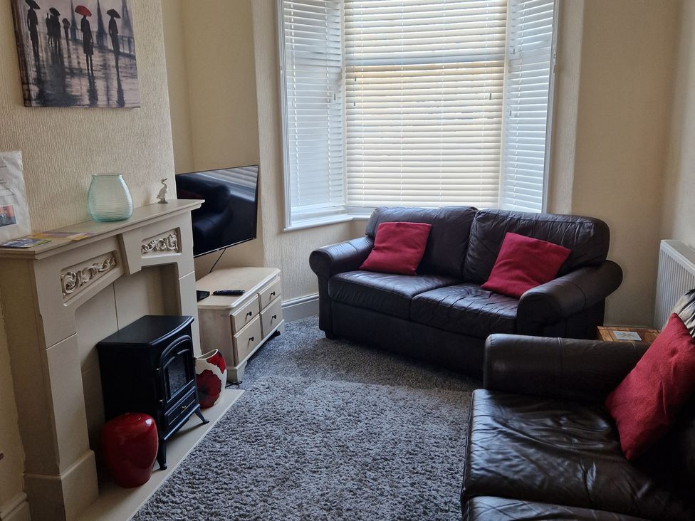 A living room with a sofa and television at 18 Howard Street in Scarborough