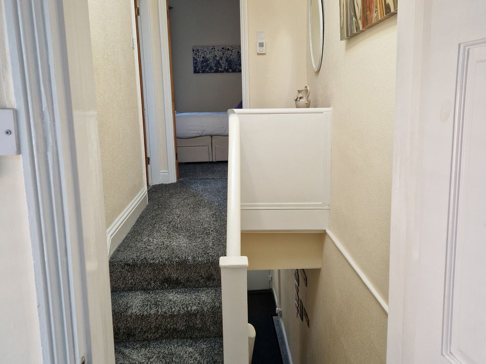 A hallway with a staircase and a mirror at 18 Howard Street Scarborough