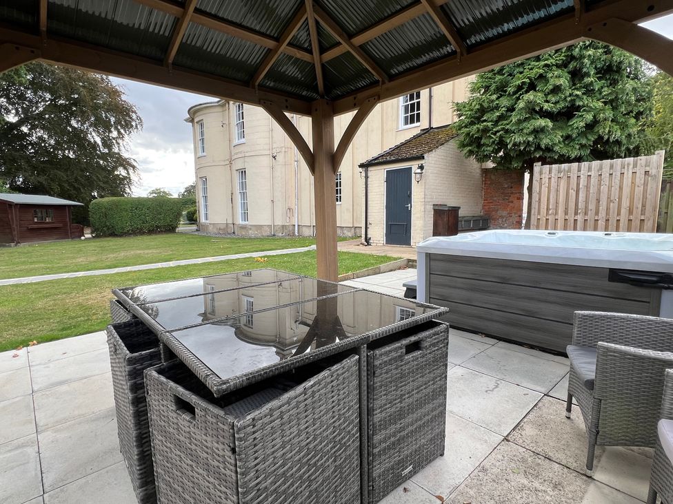 A gazebo with an outdoor table and hot tub at Moortown House Caistor