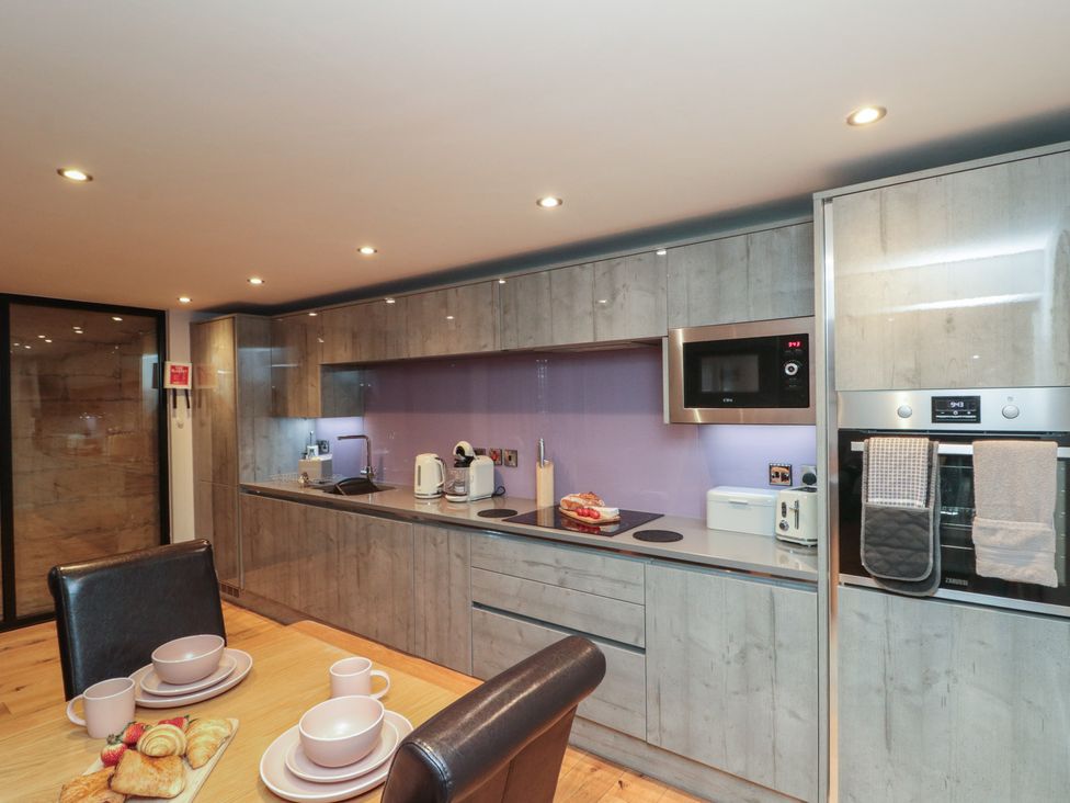 A kitchen with appliances and dining setup at Tornado @ Engine Shed Whitby