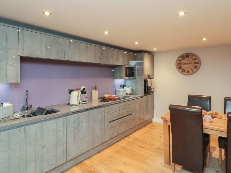 A kitchen with cabinets and a dining area at Tornado @ Engine Shed in Whitby