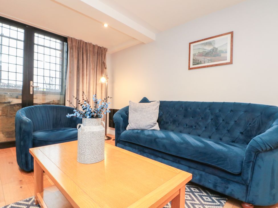 A living room with blue furniture and a window at Blue Peter @ Engine Shed Whitby