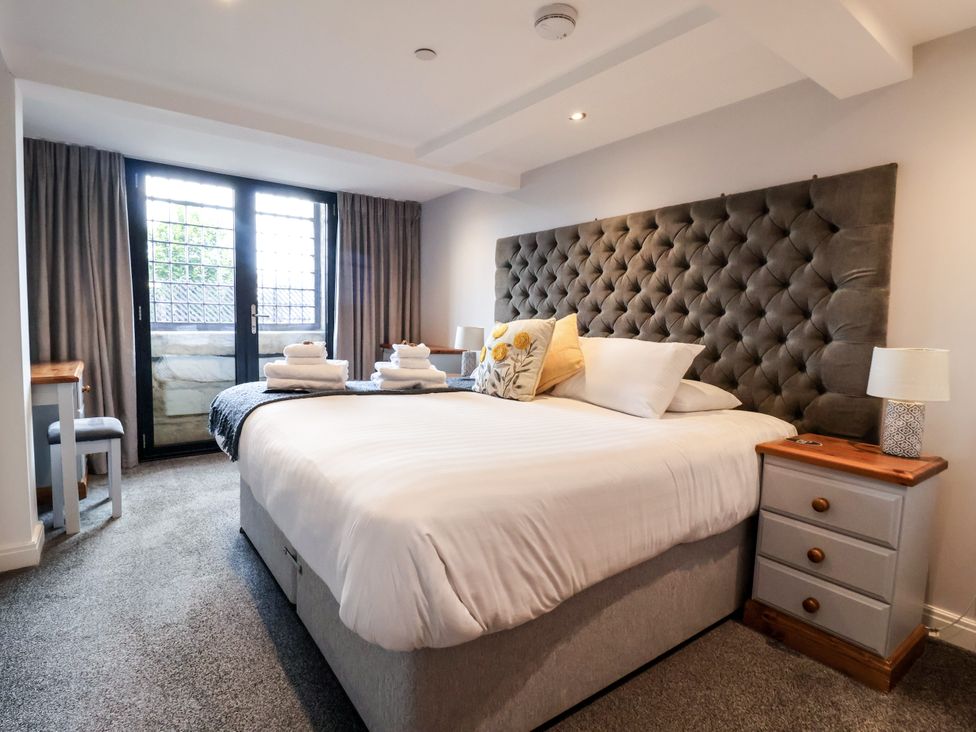 A bedroom with a bed and balcony doors at Blue Peter @ Engine Shed in Whitby