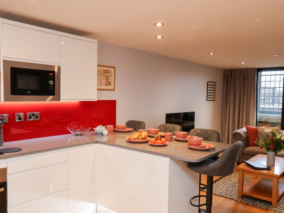 A kitchen with a bar counter and dining plates at Olton Hall @ Engine Shed Whitby