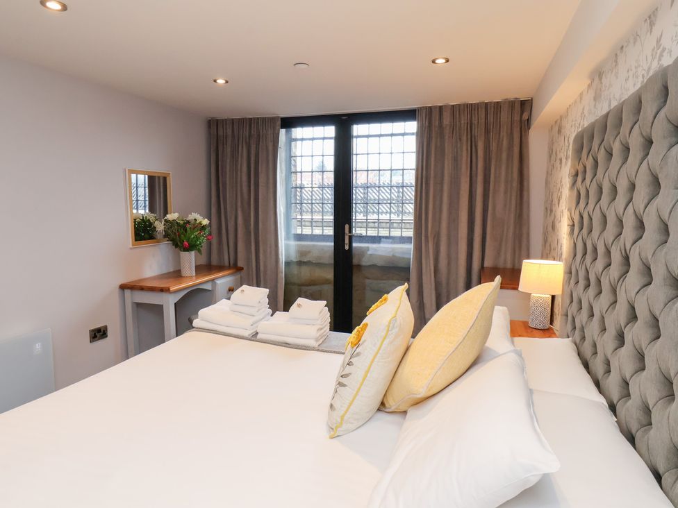 A bedroom with a bed and mirror at Olton Hall @ Engine Shed in Whitby