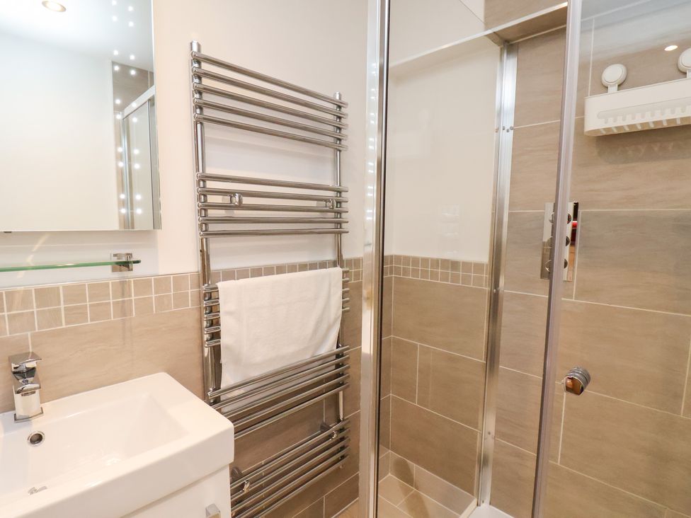 A bathroom featuring a wash basin, towel rail, and shower at Olton Hall @ Engine Shed, Whitby