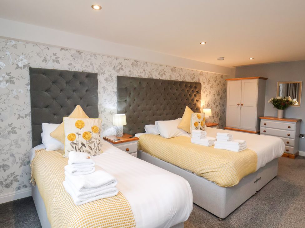 A bedroom with two beds and a wardrobe at Mallard @ Engine Shed in Whitby