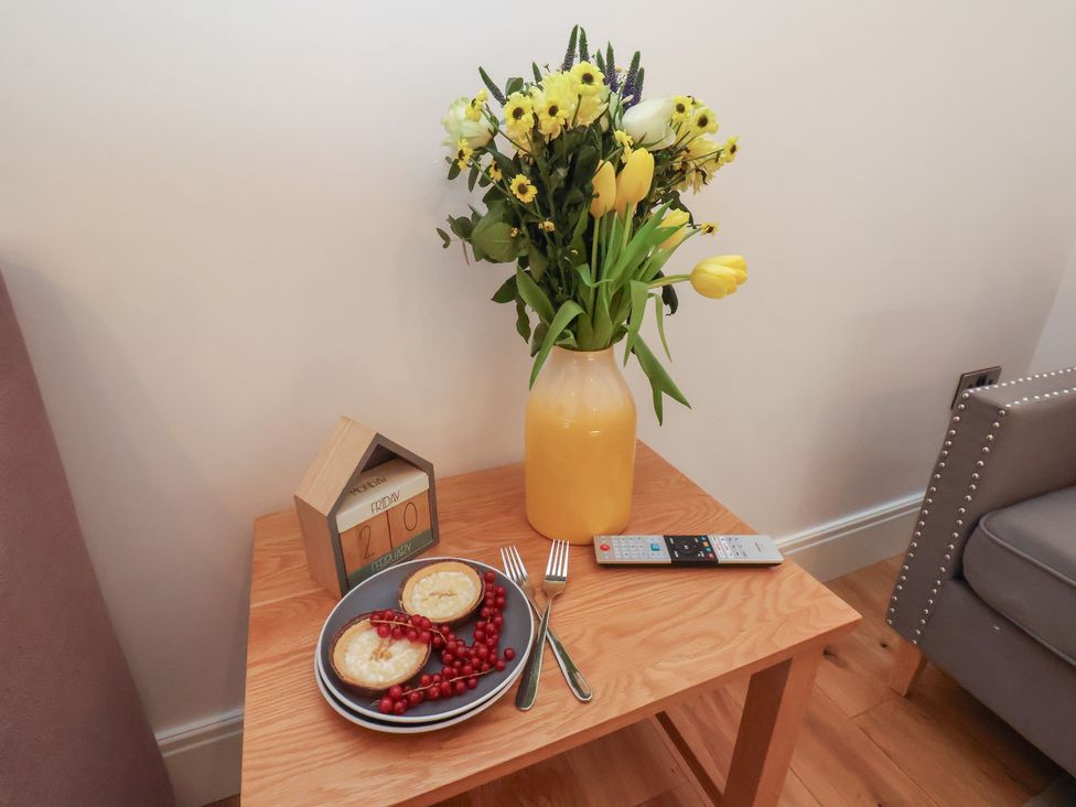 A table with flowers, food, and a remote control at Evening Star @ Engine Shed Whitby