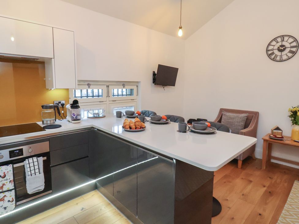 A kitchen with a dining table and appliances at Evening Star @ Engine Shed in Whitby