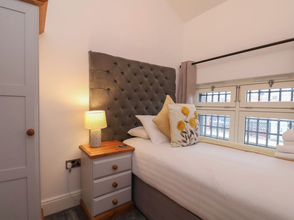 A bedroom with a single bed and bedside table at Evening Star @ Engine Shed Whitby