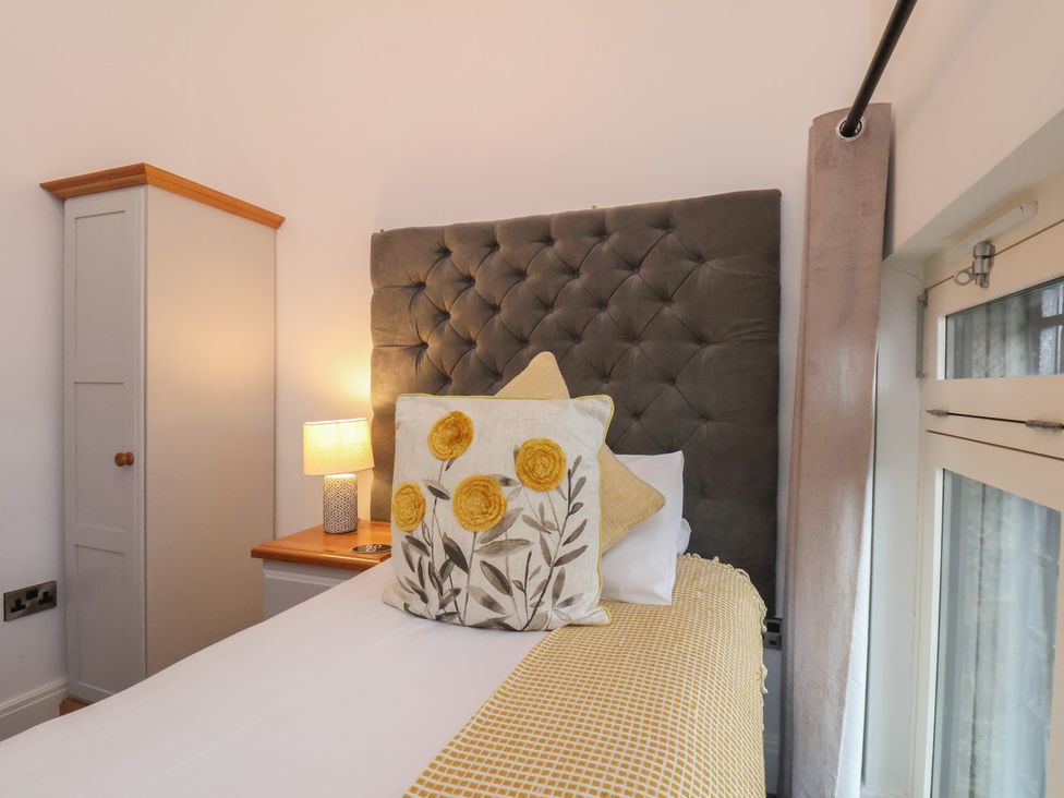 A bedroom with a bed and bedside lamp at Evening Star @ Engine Shed Whitby