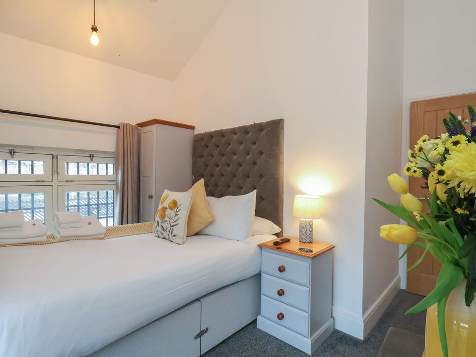 A bedroom with a bed and side table at Evening Star @ Engine Shed in Whitby