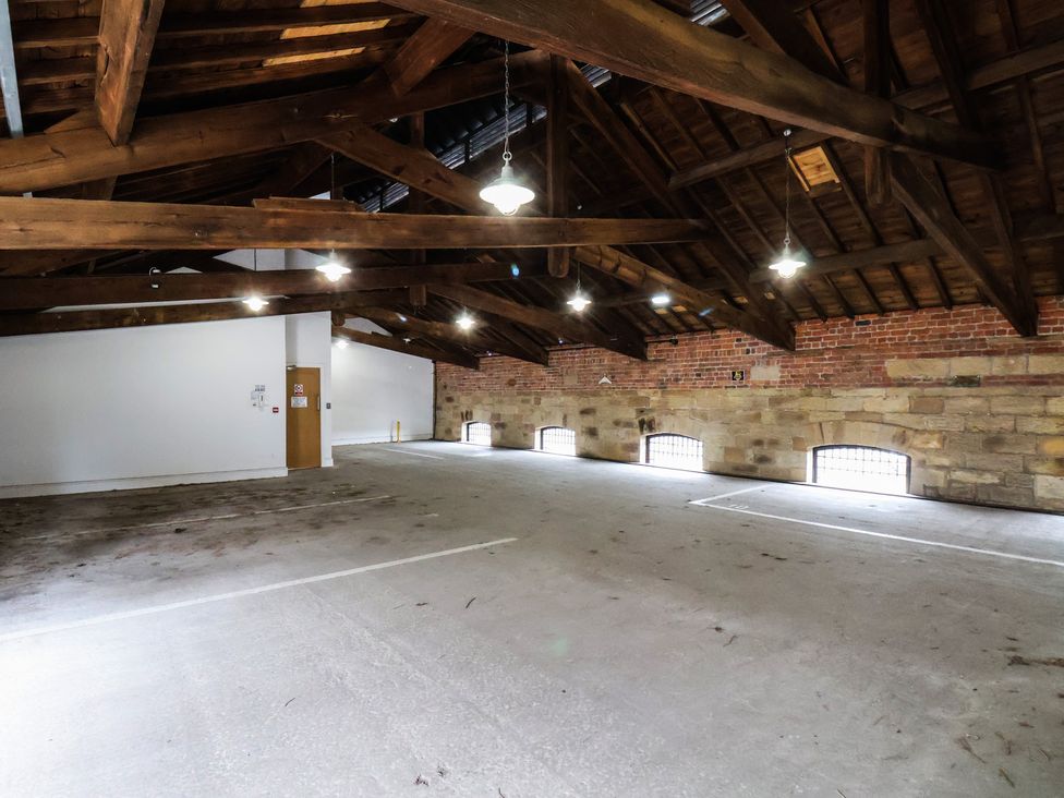 An indoor garage with wooden beams and exposed brick at Evening Star @ Engine Shed in Whitby