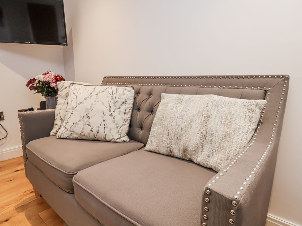 A sofa with cushions and a television in the living room at George Stephenson @ Engine Shed, Whitby