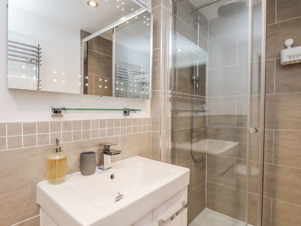 A bathroom with a sink, shower, and mirror at George Stephenson @ Engine Shed, Whitby
