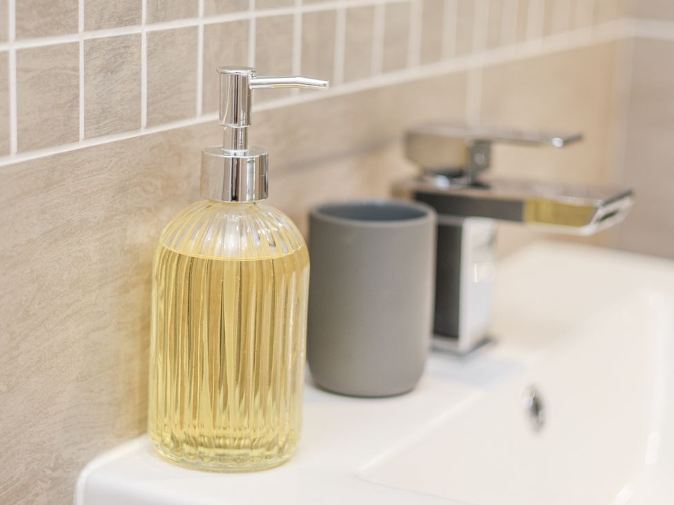 A sink with a soap dispenser and a ceramic cup at George Stephenson @ Engine Shed in Whitby
