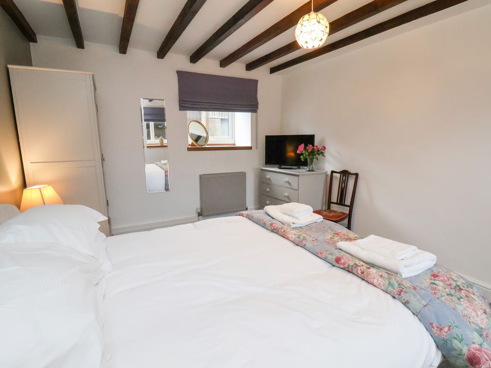A bedroom with a bed and television at Mill House in Robin Hood's Bay