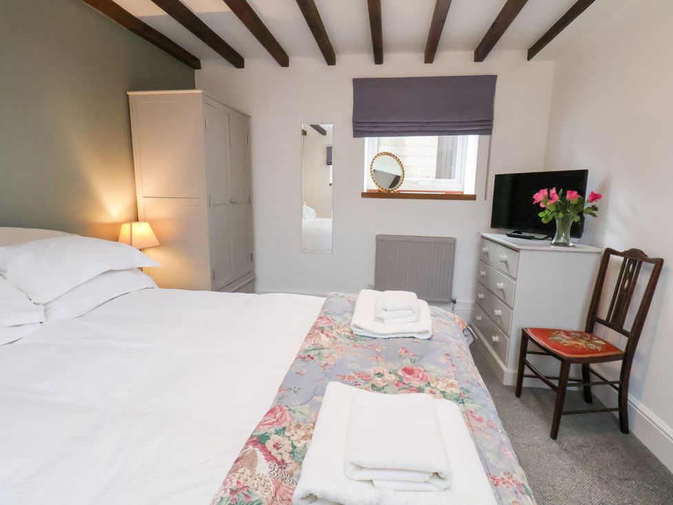 A bedroom with a bed and a wardrobe at Mill House in Robin Hood's Bay