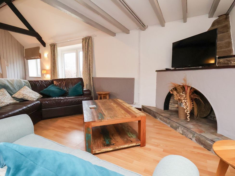 A living room with a sofa and coffee table at Stable Cottage in Robin Hoods Bay