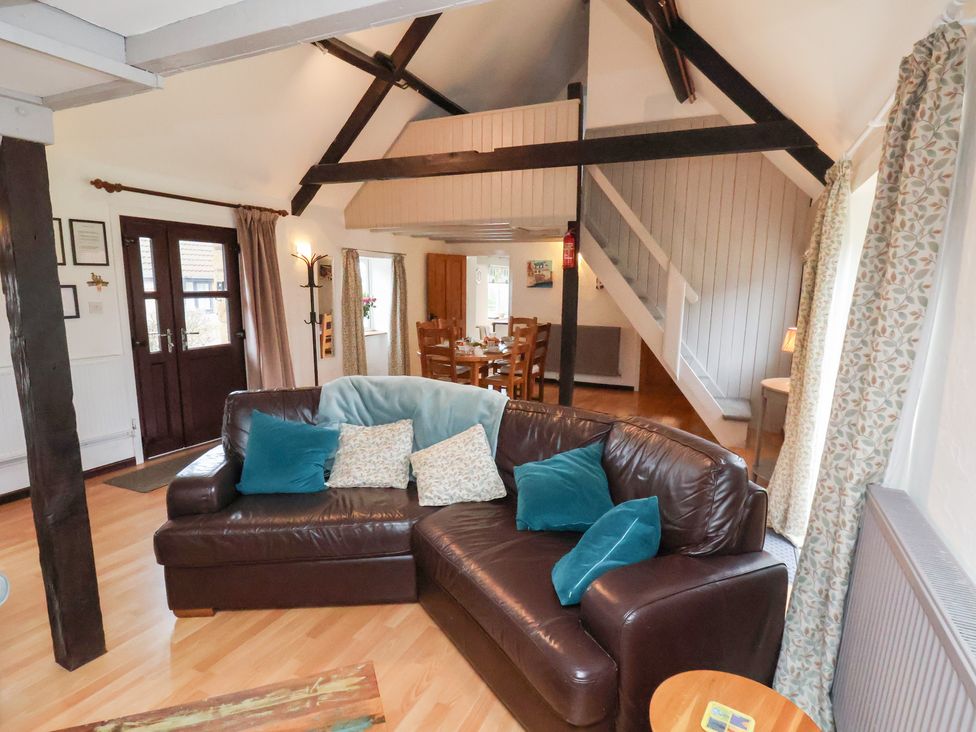 A living room with a sofa and dining area at Stable Cottage Robin Hoods Bay