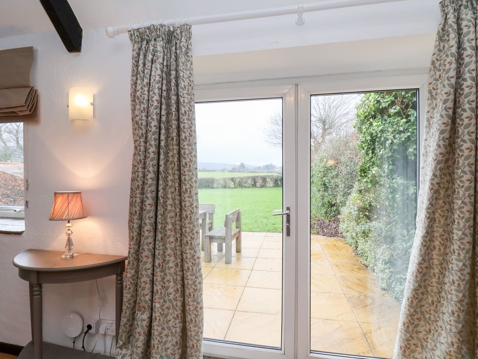 A living room with a door leading to a patio at Stable Cottage in Robin Hoods Bay