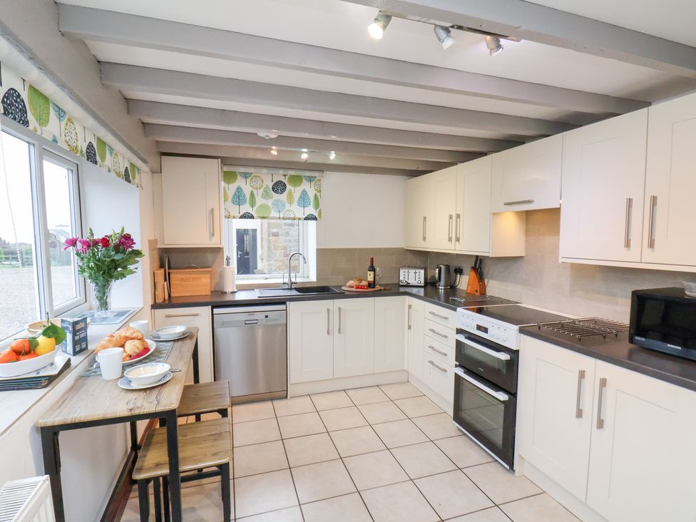 A kitchen with a table and chairs at Stable Cottage in Robin Hoods Bay