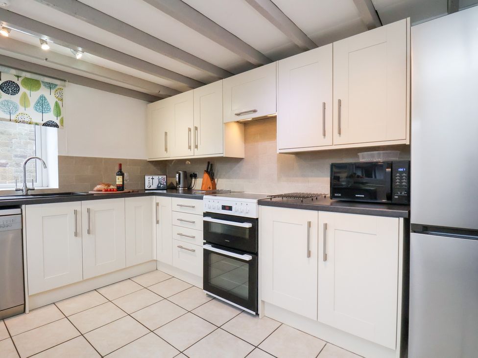 A kitchen with appliances and cabinets at Stable Cottage in Robin Hoods Bay