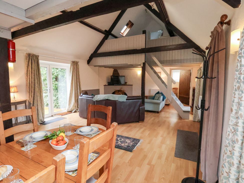 A living room with a table, chairs, and a sofa at Stable Cottage in Robin Hoods Bay