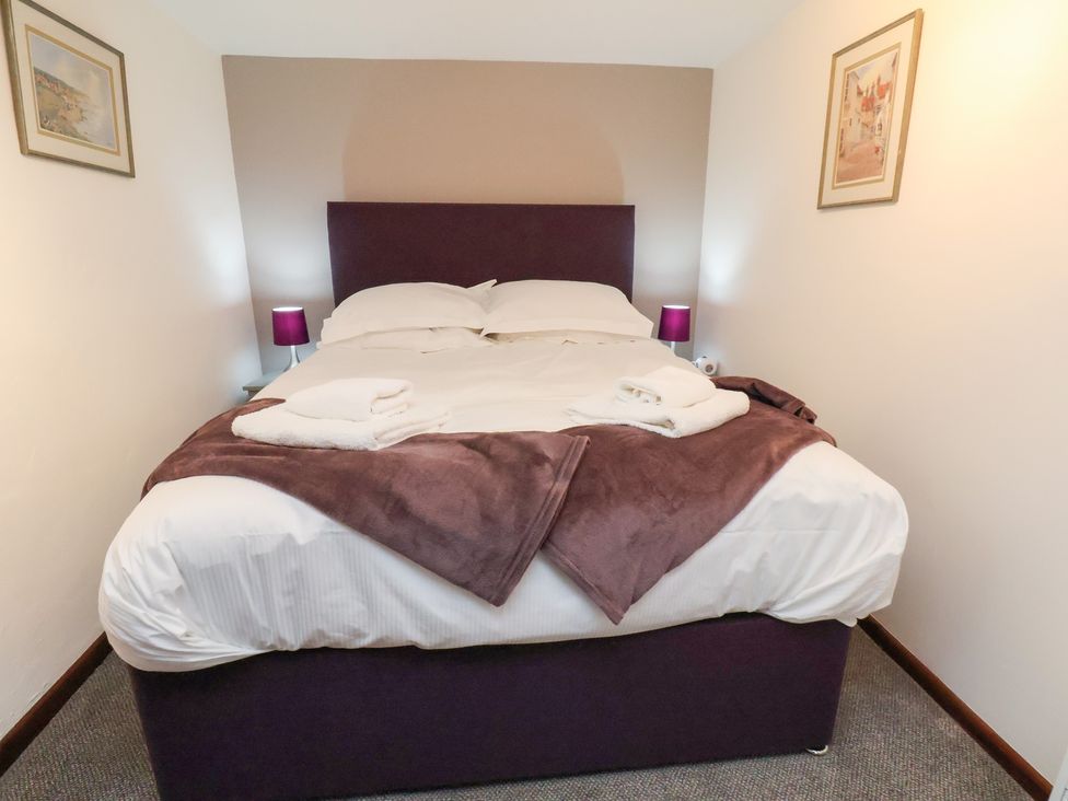 A bedroom with a bed and side tables at Stable Cottage in Robin Hoods Bay