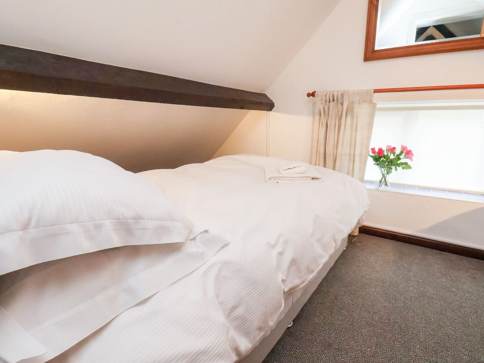 A bedroom with a bed and window at Stable Cottage Robin Hoods Bay