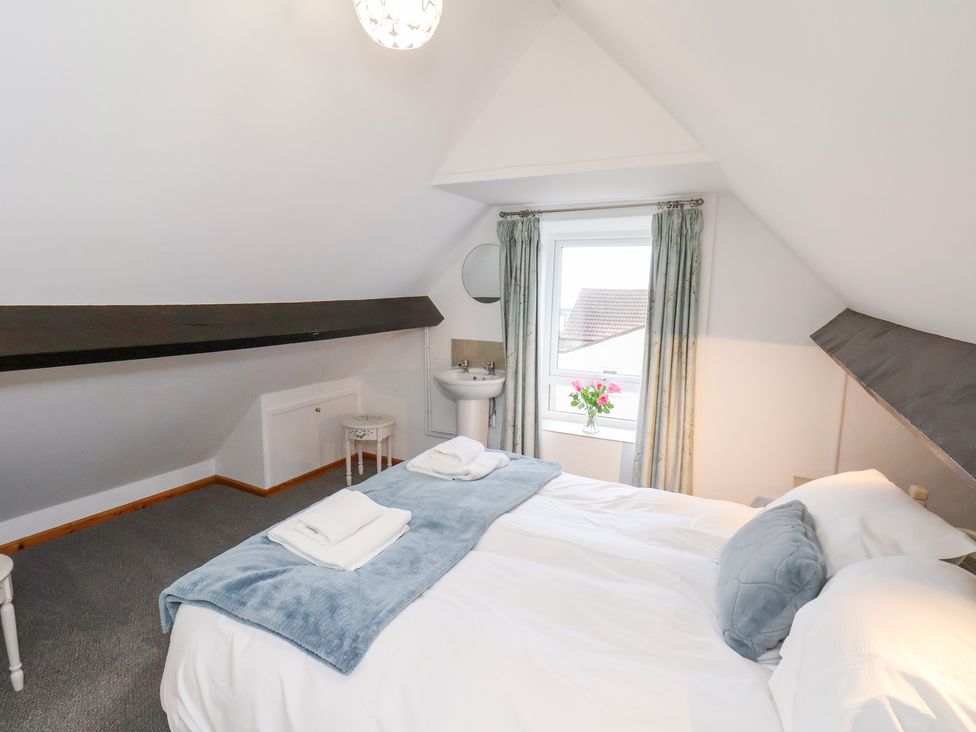 A bedroom with a double bed and a washbasin at Stable Cottage in Robin Hoods Bay