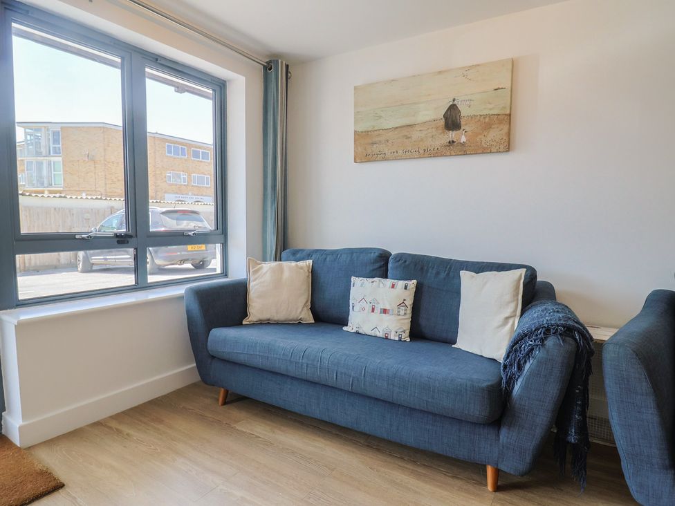 A living room with a sofa and window at Harbourwalk in West Bay