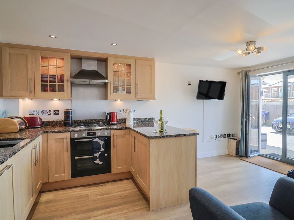 A kitchen with appliances and a television at Harbourwalk West Bay