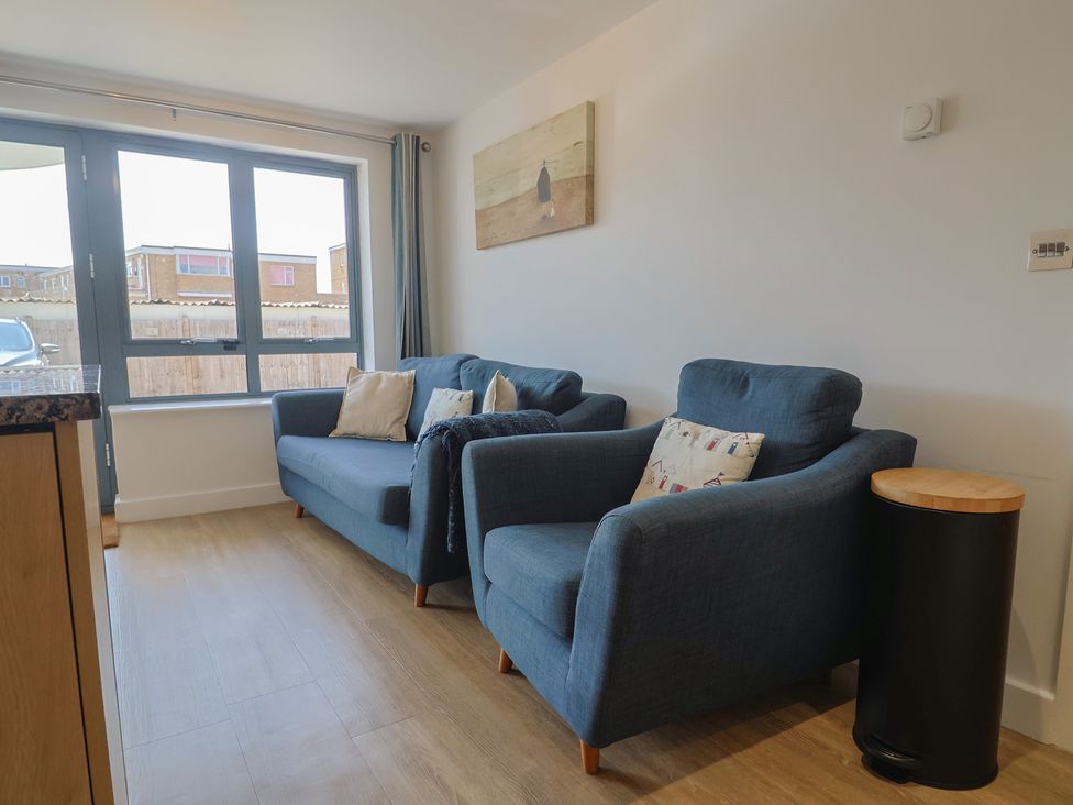 A living room with sofas and a table at Harbourwalk in West Bay