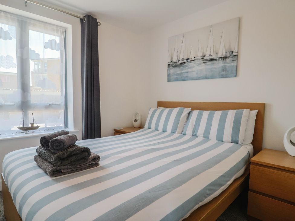 A bedroom with a bed and towels on it at Harbourwalk in West Bay
