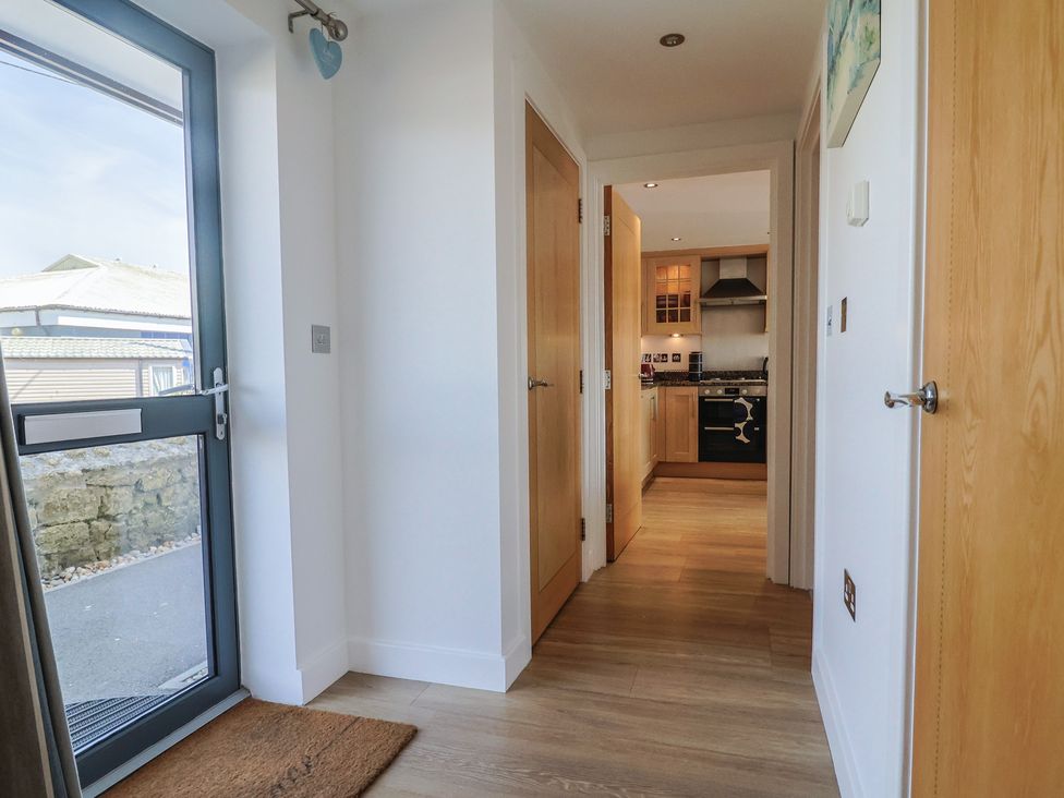 A hallway with a door leading to the kitchen at Harbourwalk in West Bay