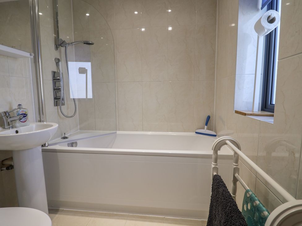 A bathroom with a bathtub and sink at Harbourwalk in West Bay
