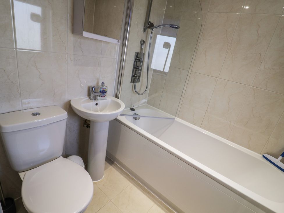 A bathroom with a toilet, sink, shower, and bathtub at Harbourwalk in West Bay