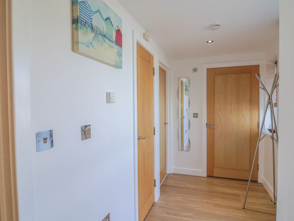 A hallway with a door and mirror at Harbourwalk in West Bay