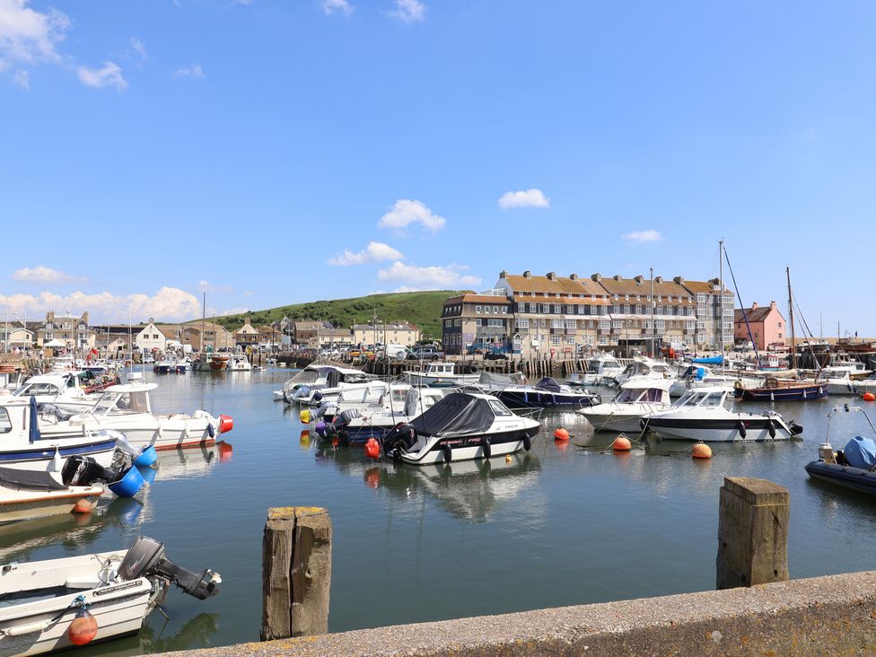 A harbor with boats and buildings at Harbourwalk in West Bay