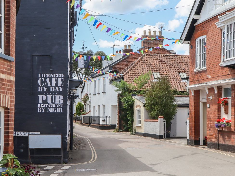 A street view with a cafe sign and colorful bunting at Meadow View Cottage in Lympstone
