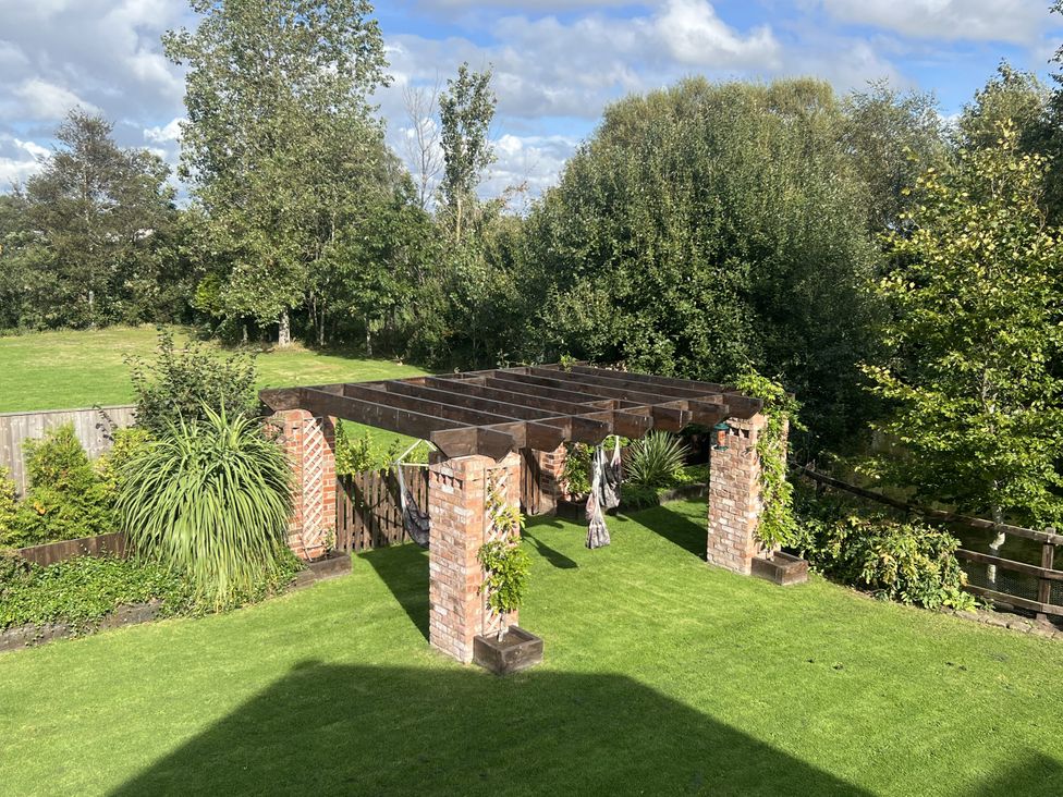 A garden with a pergola and grass at Moor End Manor Stalmine