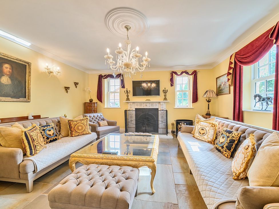 A living room with a chandelier and fireplace at Moor End Manor in Stalmine