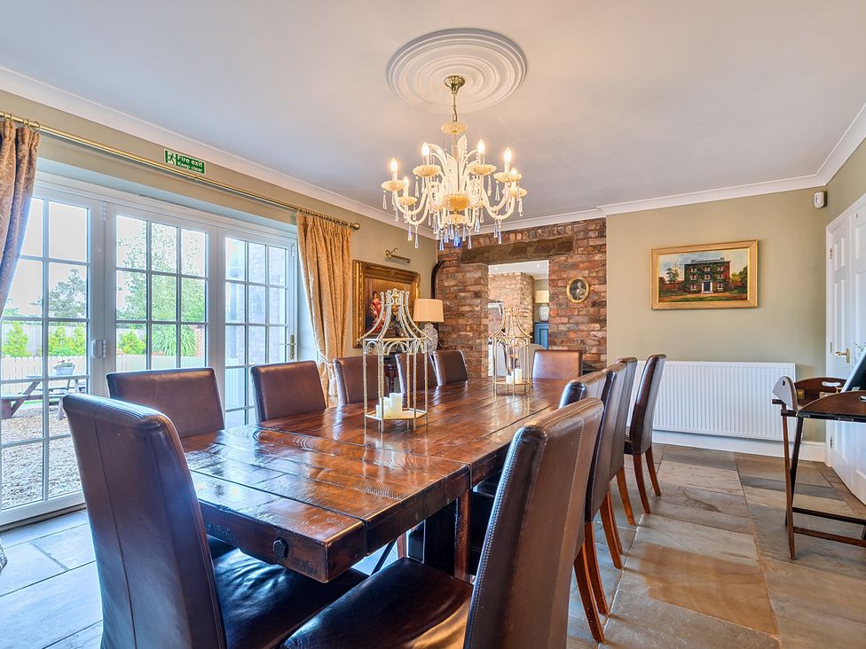 A dining room with a wooden table and chairs at Moor End Manor in Stalmine