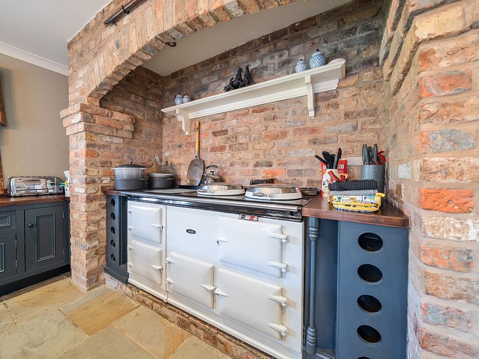 A kitchen with a cooker and wooden shelves at Moor End Manor Stalmine